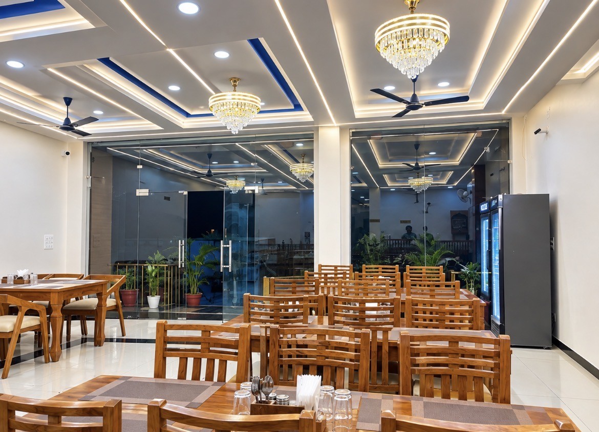 Daytime front view of Hotel Kamala & Resto building and grand glass entrance