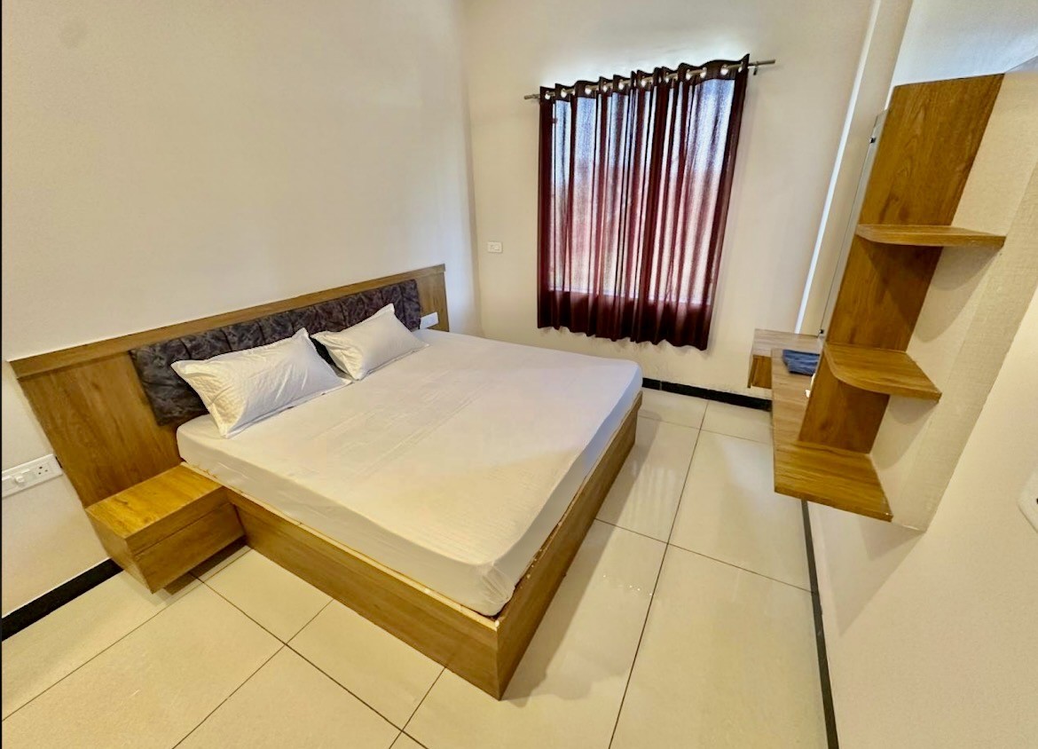 Deluxe air-conditioned bedroom with wooden wardrobe and attached bath