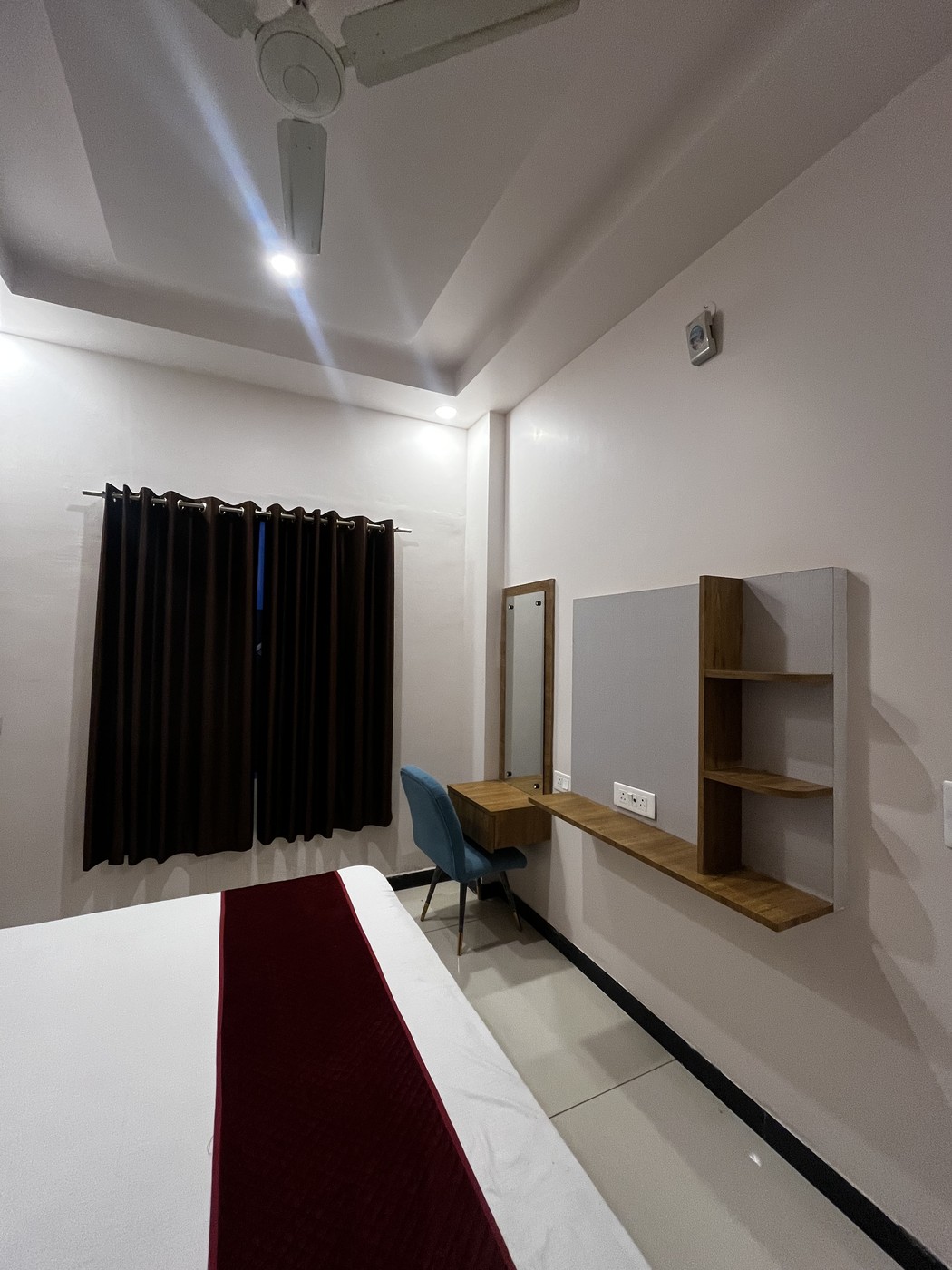 Full height window with dark blackout curtains and outdoor view